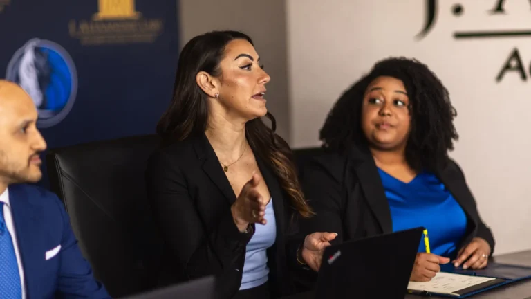 Laura Rivas making a point during a case meeting with two colleagues at the J. Alexander Law Firm office