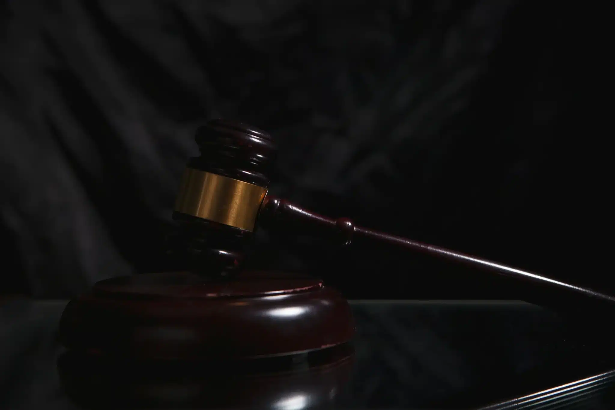 Wooden judge's gavel resting on a dark surface