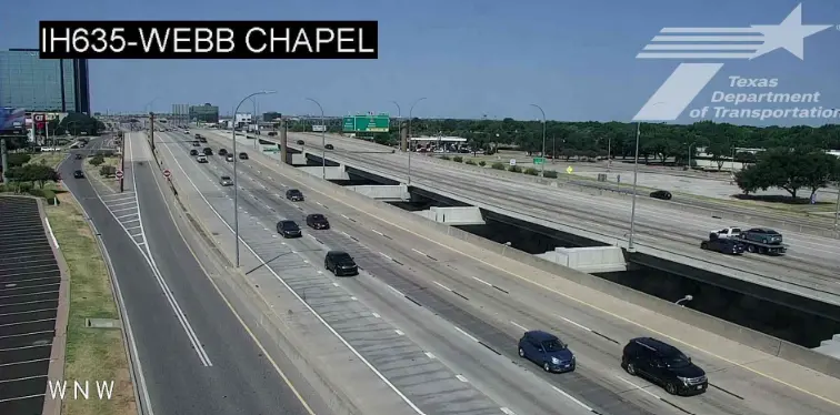 A TxDOT traffic camera view of I-635 at Webb Chapel Road in Dallas, with the camera name in the corner