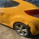 Daños cerca de la rueda trasera del auto de nuestra clienta después de que un vehículo de remolque cambiara de carril y chocara contra ella