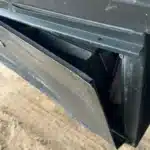 A bent panel pulled away from a compartment under the commercial trailer