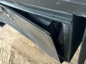 A bent panel pulled away from a compartment under the commercial trailer