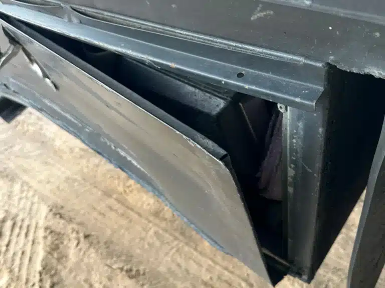 A bent panel pulled away from a compartment under the commercial trailer