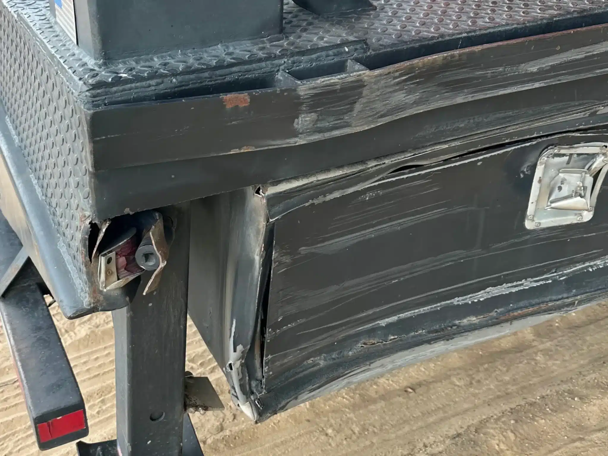 Deformed side box and torn metal at the rear corner of the commercial trailer