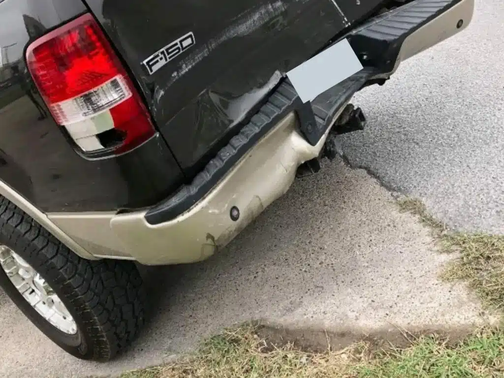 Rear quarter view of the F-150 showing the rear bumper pushed down and away from the body behind the rear wheel