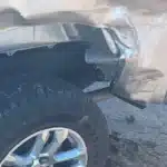 Crumpled and torn bodywork at the rear wheel opening of the client's Chevrolet Silverado after the Pasadena crash