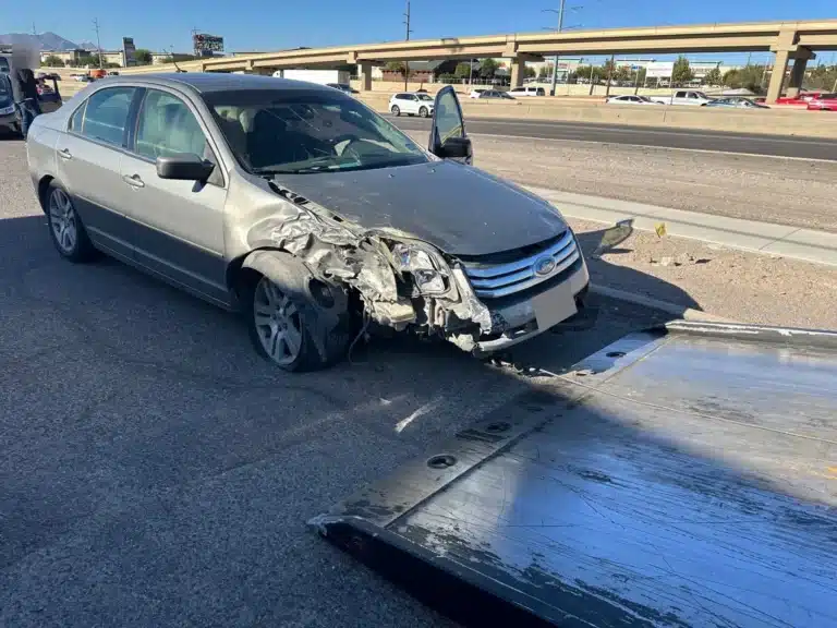 La esquina delantera derecha del sed&aacute;n plateado de nuestro cliente despu&eacute;s del accidente por no ceder el paso en El Paso, con la salpicadera y el faro desgarrados