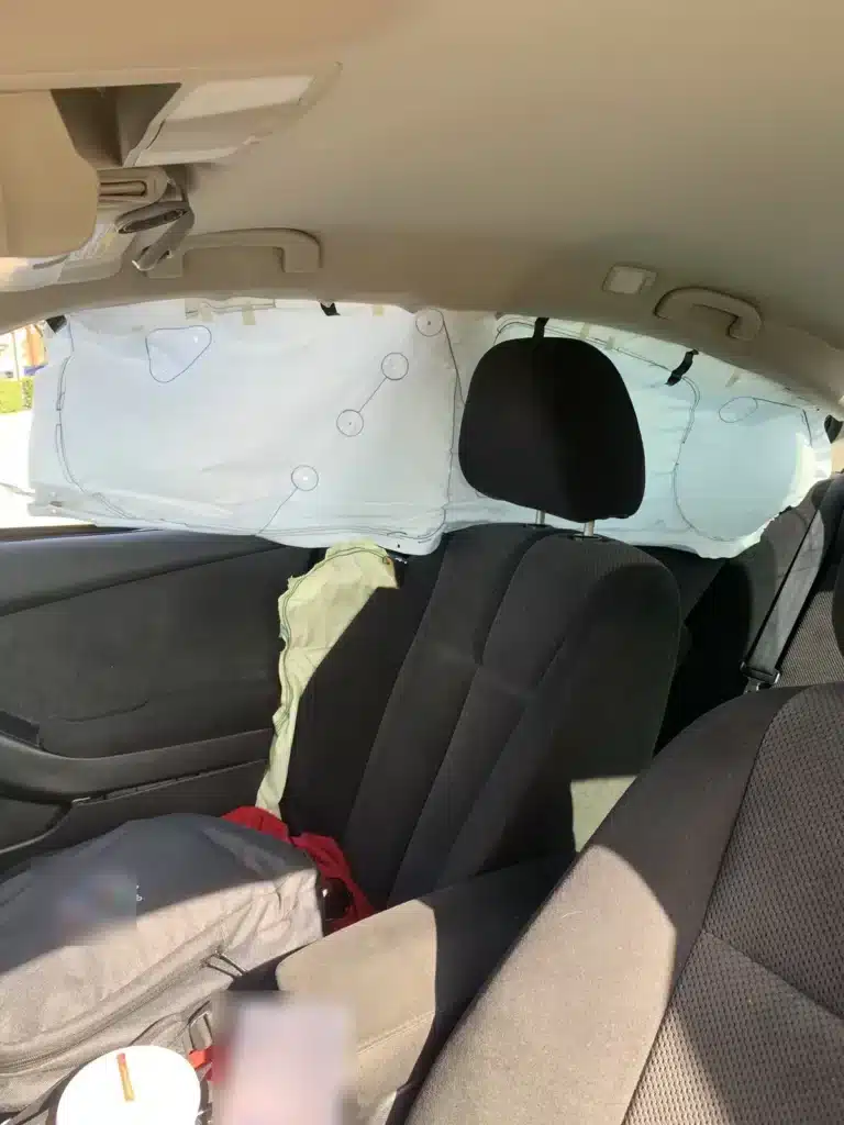 Interior del sed&aacute;n de nuestra clienta con el airbag de cortina lateral desplegado a lo largo de las ventanas y el airbag lateral del asiento desplegado