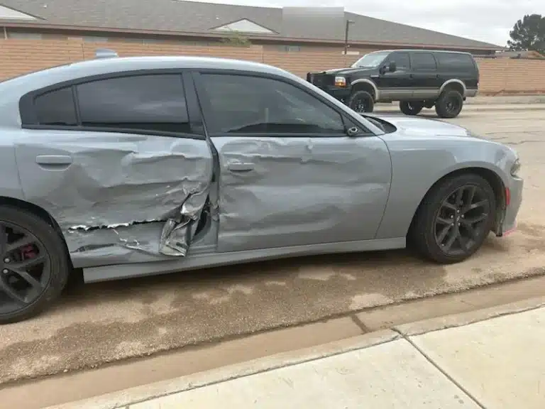 El lado del pasajero del sed&aacute;n gris de nuestras clientas despu&eacute;s del accidente en Odessa, con las puertas delantera y trasera hundidas donde choc&oacute; la camioneta de la empresa